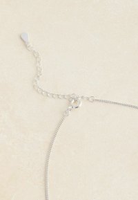 Strieborná retiazka na náhrdelník s karabínkovým zapínaním a nastaviteľnými článkami, s hladkým povrchom a minimalistickým dizajnom.