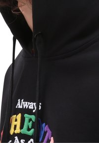 Felpa nera con cappuccio, dotata di lacci e con il testo ricamato e colorato "Always THE" sulla parte anteriore. Il materiale è morbido e ha una consistenza liscia.