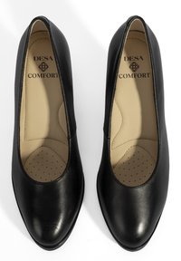 Zwarte leren pumps met een ronde neus, gevoerde binnenzool met perforaties, en een interieur gemarkeerd met "DESA COMFORT." Gladde textuur.