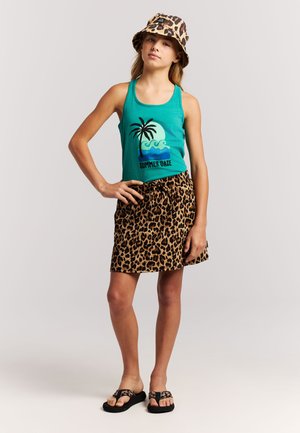 Grünes Tanktop mit Palmenmotiv, kombiniert mit einem Leopardenmuster-Rock. Dazu ein passender Bucket-Hut im Leopardenmuster. Schwarze Sandalen zum Hineinschlüpfen.