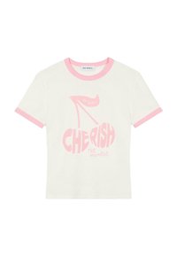 T-shirt à manches courtes, couleur crème avec finitions roses, présentant un imprimé graphique d'une chaussure à talon et le texte "CHÉRISSEZ le moment."