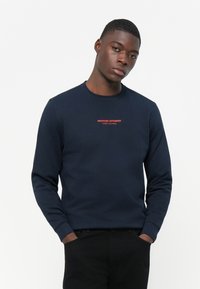 Navy blue sweatshirt made of cotton with long sleeves. Features a red "WEEKEND OFFENDER" logo and "ADMIT NOTHING" text on the chest.