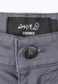 Gray fabric with a smooth texture, featuring a black tag that reads "DAVE" above "FORMER" and a black button with an embossed "F" logo.