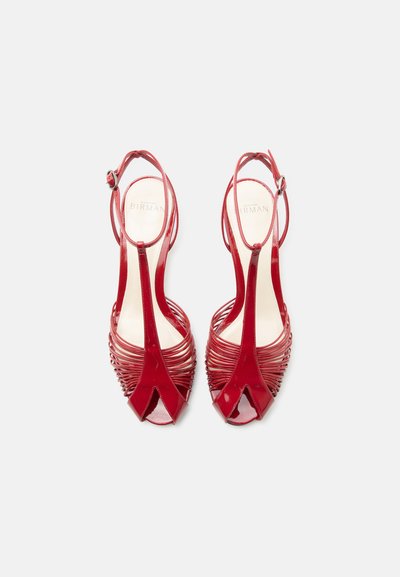 Κόκκινα γυαλιστερά σανδάλια με ψηλά τακούνια και ιμάντες στον αστράγαλο, ανοιχτές μύτες και πολλαπλούς λεπτούς οριζόντιους ιμάντες πάνω στο πόδι.