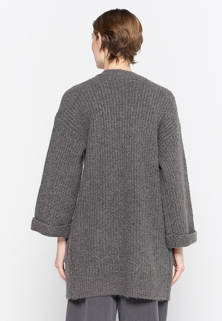 Langer, grauer Strickcardigan mit strukturiertem Muster, weit geschnittenen Ärmeln und lockerer Passform, mit umgeschlagenen Bündchen und offenem Rückendesign.