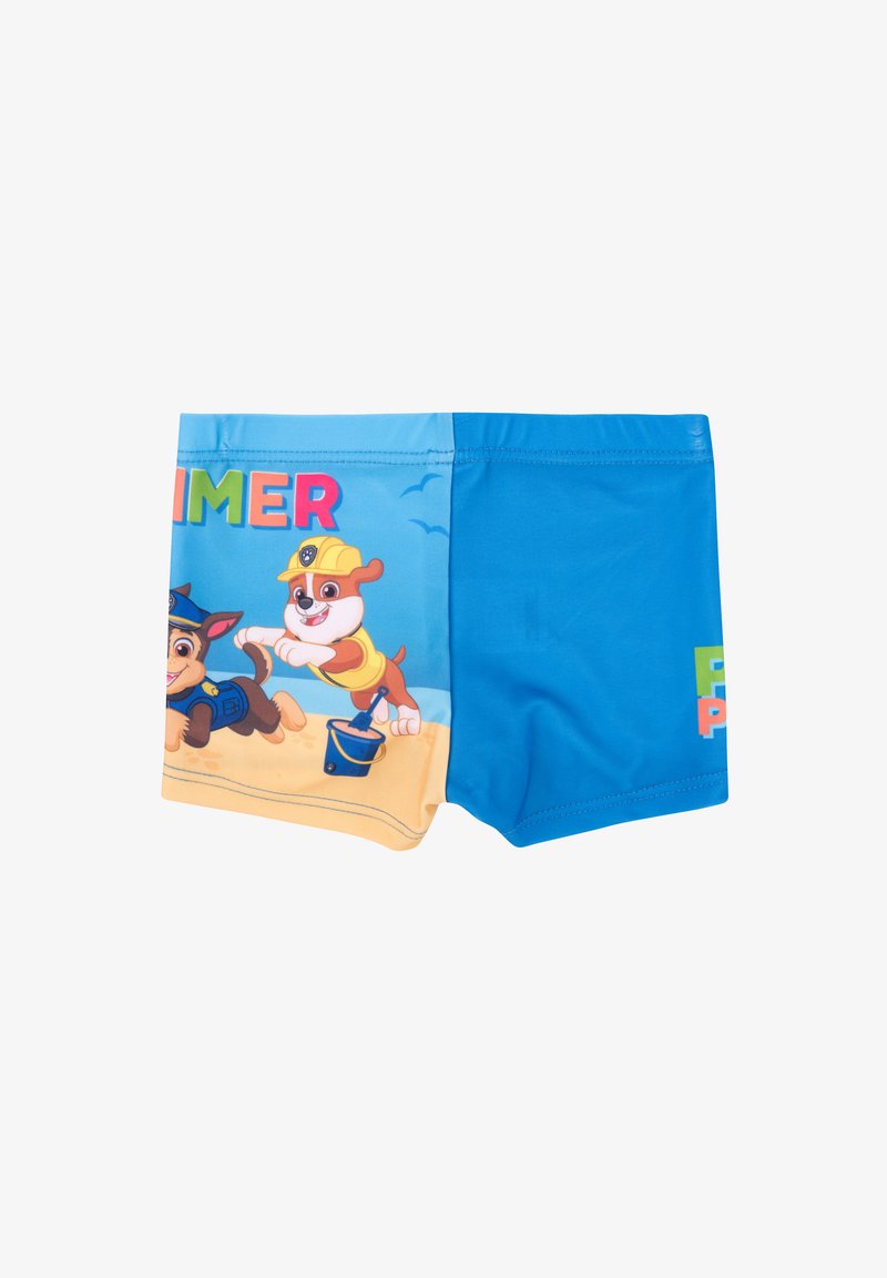 Costumi da bagno blu con personaggi animati sulla parte frontale, con la scritta "ESTATE" sopra e un design colorato su uno sfondo di spiaggia sabbiosa.