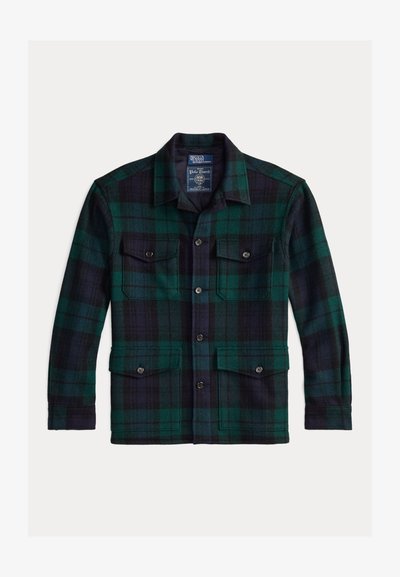 Gyapjú flanel dzseki sötétzöld és tengerészkék kockás mintával. Jellemzője a hegyes gallér, két, gombos zsebbek elöl, és egyenes szegély.