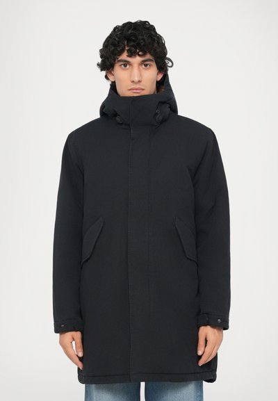 Parka noire avec un col montant, fermeture à boutons, poches latérales et un tissu légèrement texturé. Présente une coupe droite et décontractée.