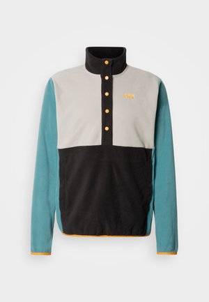 Fleece-Pullover mit hohem Kragen. Verfügt über schwarze, graue und türkise Einsätze, orangefarbene Knopfdetails und ein Logo auf der Brust.