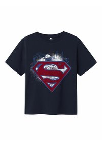 Camiseta azul marino que presenta un logotipo rojo de Superman con gráficos estilizados y texto de fondo, diseñada para los fans del personaje.