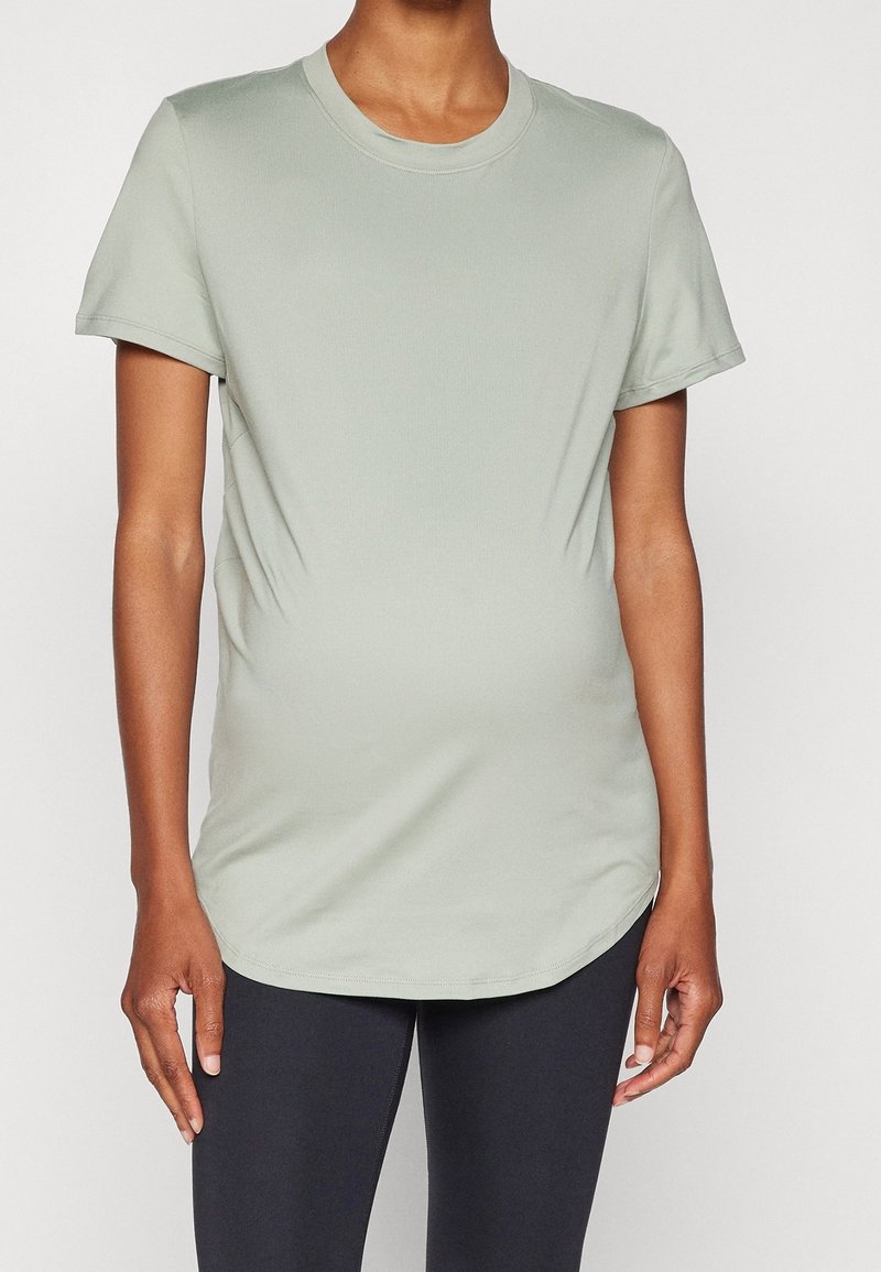 Camiseta verde claro hecha de tela suave, con mangas cortas y escote redondeado, que presenta un corte relajado y un dobladillo curvado.