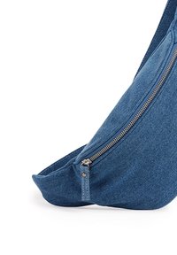Denimová kabelka přes rameno s oblým tvarem, vybavená stříbrným zipem a strukturovaným povrchem. Barva je střední modrá s detaily zesíleného šití.