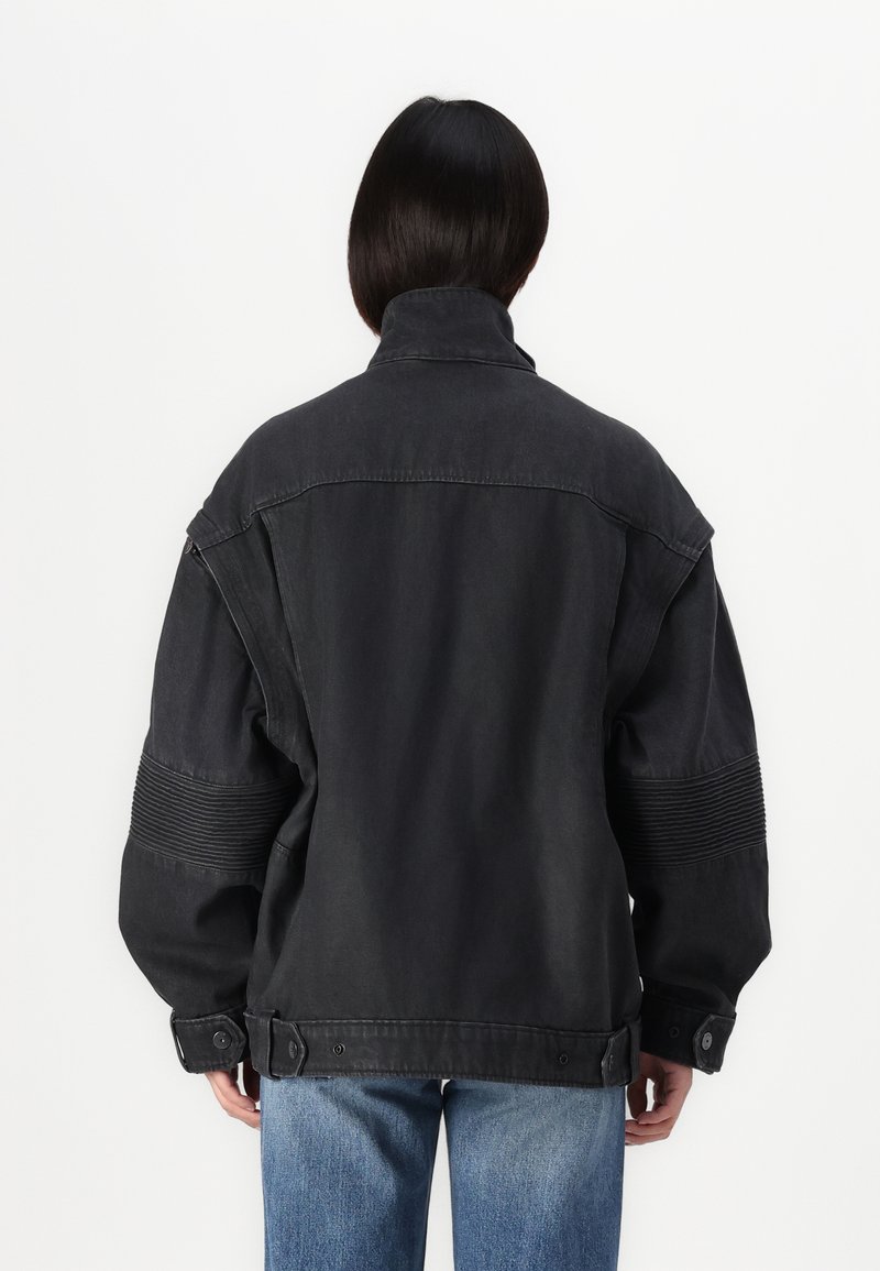 Veste en denim noire surdimensionnée avec un col haut, des accents côtelés sur les manches, et des fermetures à boutons aux poignets et à l'ourlet.