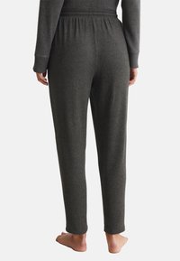 Donkergrijze sweatpants met een elastische tailleband en ribgebreide boorden, gemaakt van zachte stof, met een rechte pijpdesign en minimale details.