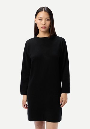 Schwarzes, langärmeliges Strickkleid mit rundem Halsausschnitt und geradem Schnitt. Weiche Textur mit knieumspielendem Saum. Keine sichtbaren Muster oder Verzierungen.