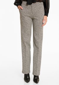 Grijze en zwarte gestreepte broek met een rechte pasvorm, voorzien van zijzakken en een ontspannen fit, gecombineerd met zwarte hakken.