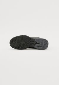 Schwarze Sport-Schuhsohle mit einem strukturierten Muster, das Rillen für Griffigkeit und einen Logo-Druck aufweist. Strapazierfähiges Gummimaterial.