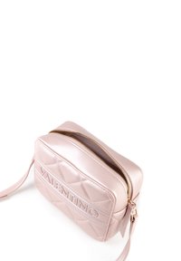 Borsa a tracolla in pelle trapuntata rosa con zip dorata e dettaglio del logo. Forma rettangolare compatta con tracolla rimovibile.