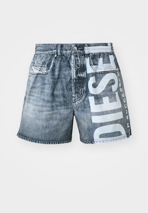 Denim short met een vervaagde blauwe kleur en een ruwe zoom. Heeft een groot wit logo op de voorkant en een klein zakje aan de linkerkant.