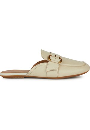Scarpa in pelle crema senza lacci con punta arrotondata, cinturino decorativo e dettaglio in metallo dorato. Presenta una suola piatta in gomma beige.