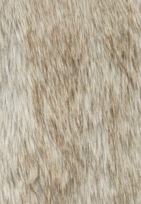 Fibre à la texture douce avec une palette de couleurs beige et brun clair, présentant des nuances variées et des motifs naturels sur toute la surface.