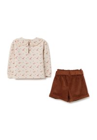 Lange mouwen crèmekleurige top met bloemenprint en ruffle kraag, gedragen met roestbruine corduroy shorts met een elastische tailleband en een omgeslagen zoom.