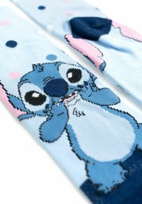 Calzini blu con un design giocoso di personaggi su uno sfondo azzurro chiaro, dettagli in rosa e blu scuro.