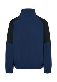 Mörkblå jacka med svarta axelinslag, hög krage, elastiska cuffs och midja. Slät textur med en lätt design.