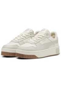 Sneakers in pelle color crema con suola in gomma piatta, punta arrotondata, design con lacci e un logo sottile sui lati e sulla linguetta.