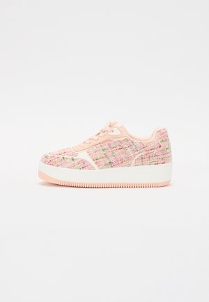 Niski sneaker na platformie z pastelowo różowym wierzchem z tweedu, jasnoróżowymi sznurowadłami i grubą białą podeszwą z różowym bieżnikiem, widziany z boku na białym tle.
