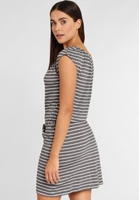 Vestido a rayas gris y blanco, confeccionado en suave algodón, con un cuerpo ajustado, mangas cortas y una falda acampanada con detalle de cinturón.