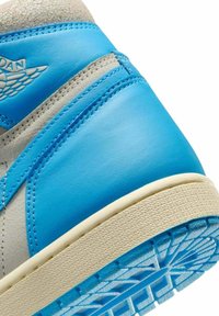 Sneaker in pelle blu con una parte superiore in suede grigia, intersuola testurizzata e un motivo dettagliato sulla suola in gomma. Marchio Jordan visibile.