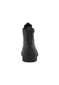 Botte chelsea noire en cuir avec une texture lisse, un bout arrondi et un petit talon carré. Présente une languette et des coutures discrètes.