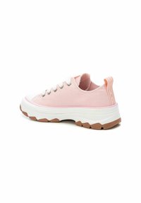 Zapatillas de lona rosas con una puntera de goma blanca, suela media blanca texturizada y suela exterior de goma marrón. Presentan ojales plateados y una lengüeta.