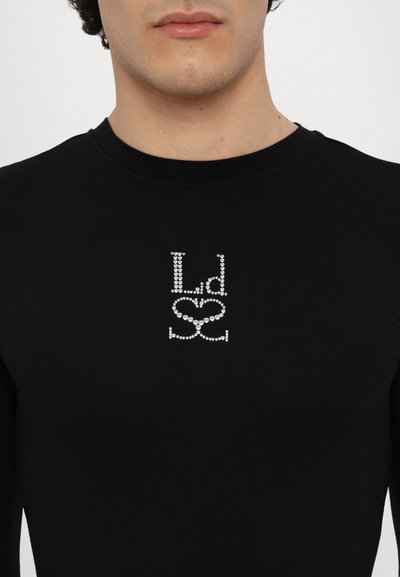 Schwarzes Langarmshirt mit einem dekorativen, mit Kristallen besetzten Logo in Silber, mit einem figurbetonten Schnitt und glatter Textur.