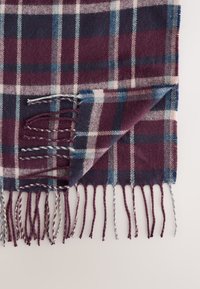 Sciarpa in lana a quadri nei colori bordeaux e blu navy, con bordo sfrangiato e frangia intrecciata. Tessuto morbido con motivo a scacchi su tutta la superficie.