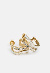Pendientes de aro en tono dorado con acentos blancos, que presentan una fila de strass transparentes y el logo grabado "GUESS" en la superficie.