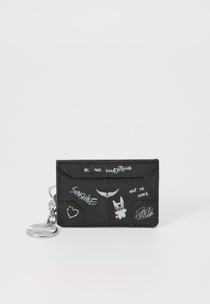 Sort læder kort holding med sølv hardware, der har grafisk tekst og illustrationer i hvid, inklusive et hjerte og en tegneseriefigur.