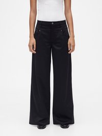 Pantalon noir à jambes larges fabriqué dans un tissu lisse et mat. Comprend des poches avant et une fermeture à bouton avec des accents métalliques.