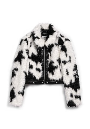 Cropped jas van namaakbont in zwart-wit koeienpatroon, met een zwart leren voorkant, zilverkleurige details en een puntige kraag.