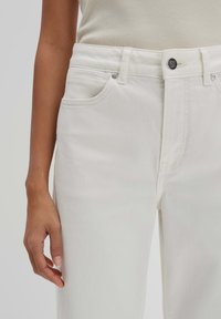 White denim jeans with a straight cut, featuring front pockets, a button closure, and subtle stitching details.