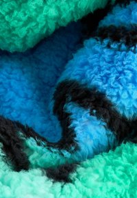 Multifarvet fleece-stof i grønne, blå og sorte nuancer med en struktureret, fluffy overflade og abstrakt mønster.