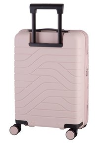 Valigia rigida di colore rosa pallido con motivo a onde, manico nero retrattile e quattro ruote nere per la mobilità.