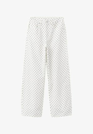 Weiße, hoch taillierte, weit geschnittene Hosen mit kleinen schwarzen Polka-Dots, vorderer Knopfleiste und Taschen.