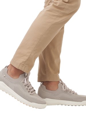 Baskets de sport beige clair avec une tige en mesh, orteil arrondi et semelle en caoutchouc blanche. Comprend des lacets plats et des détails texturés sur le côté.
