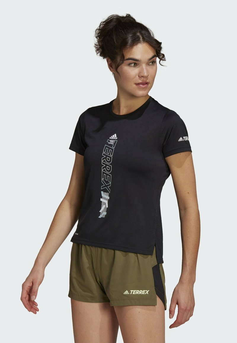 T-shirt de sport noir à manches courtes avec le logo TERREX en lettres blanches bold, doté d'un col rond et de fentes sur les côtés pour améliorer la respirabilité.