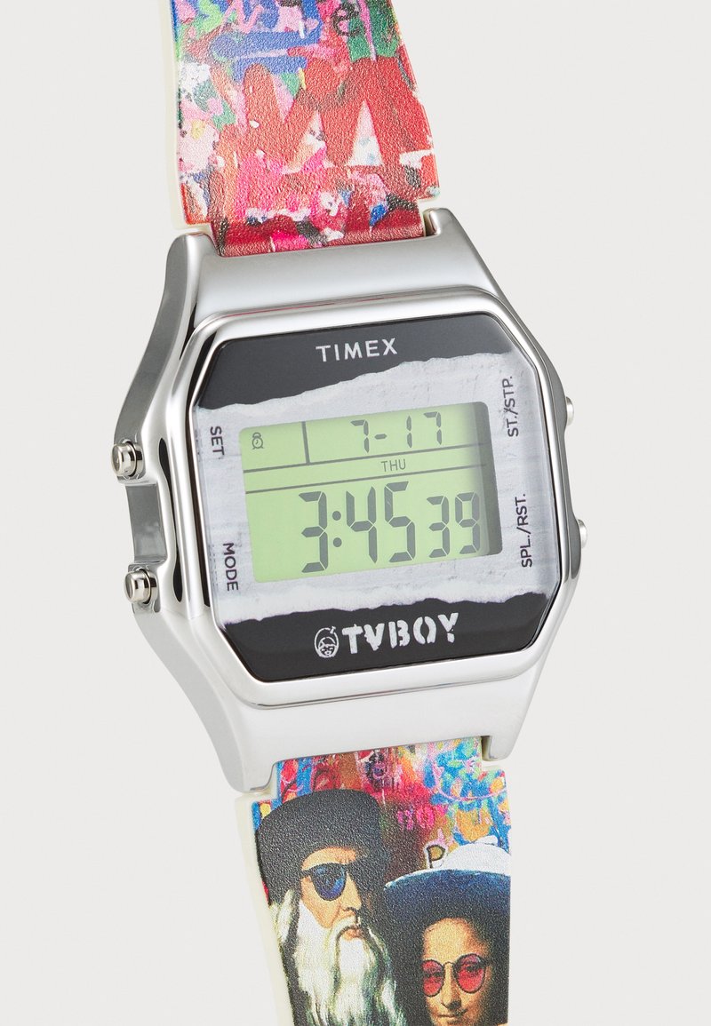 Reloj digital con caja de acero inoxidable, pantalla LCD verde y una correa de patrón colorido con gráficos artísticos.