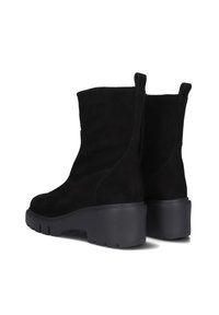 Black suede ankle boots with a textured finish, featuring a chunky rubber sole and pull tabs for easy wear. Cut design above the ankle.