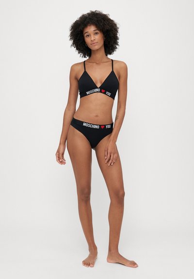 Czarny zestaw bikini z trójkątnym biustonoszem i pasującymi majtkami z białym i czerwonym napisem "MOSCHINO ❤️ YOU" na paskach. Miękka tekstura materiału.