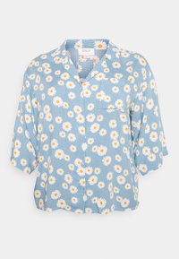 Blusa de manga curta feita de tecido leve, com fundo azul e estampas de margaridas brancas e amarelas, e fechamento frontal com botões.
